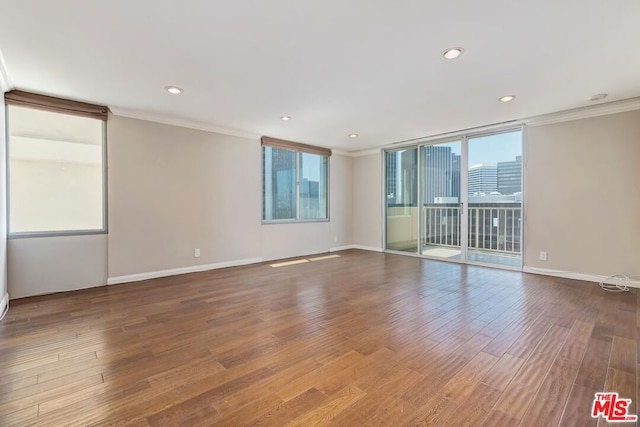 empty room featuring hardwood / wood-style flooring and ornamental molding