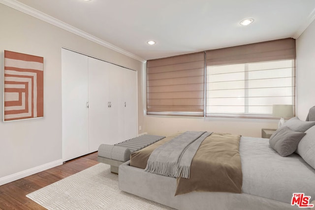 bedroom featuring a closet, hardwood / wood-style floors, and ornamental molding