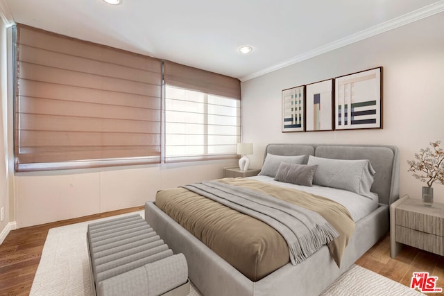 bedroom with hardwood / wood-style flooring and crown molding