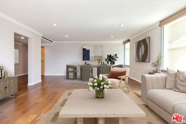 living room featuring light wood-type flooring and crown molding