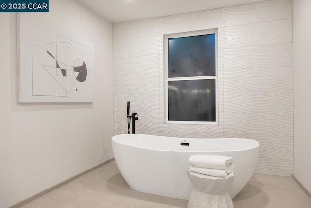 bathroom featuring tile walls and a washtub