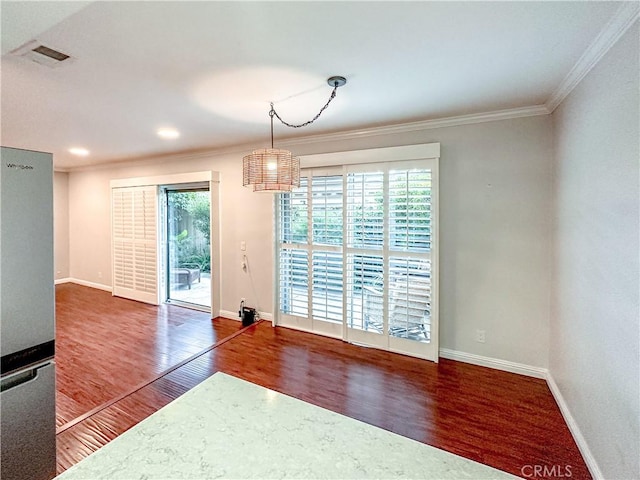 unfurnished dining area featuring ornamental molding, dark wood-type flooring, visible vents, and baseboards