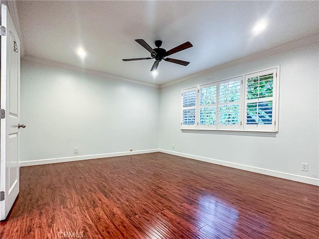 spare room featuring ornamental molding, dark wood-type flooring, baseboards, and a ceiling fan