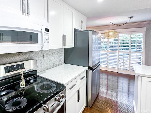 kitchen with appliances with stainless steel finishes, tasteful backsplash, dark wood-type flooring, white cabinetry, and hanging light fixtures