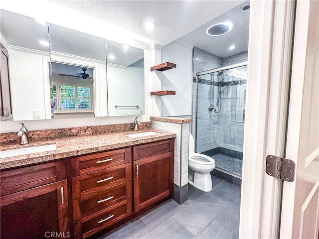 full bath featuring double vanity, a stall shower, toilet, and a sink