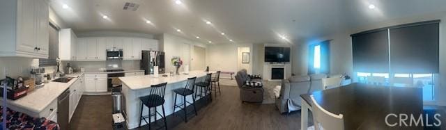 kitchen featuring white cabinetry, a center island, sink, dark hardwood / wood-style floors, and appliances with stainless steel finishes