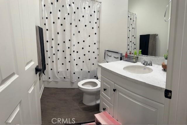 full bathroom featuring shower / tub combo with curtain, vanity, wood-type flooring, and toilet