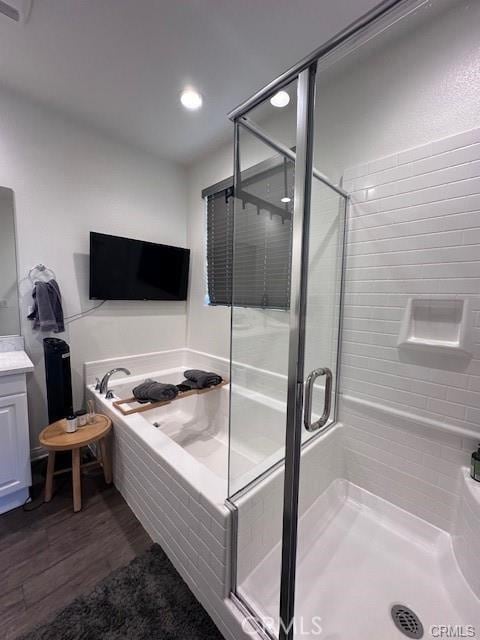 bathroom featuring wood-type flooring, vanity, and shower with separate bathtub