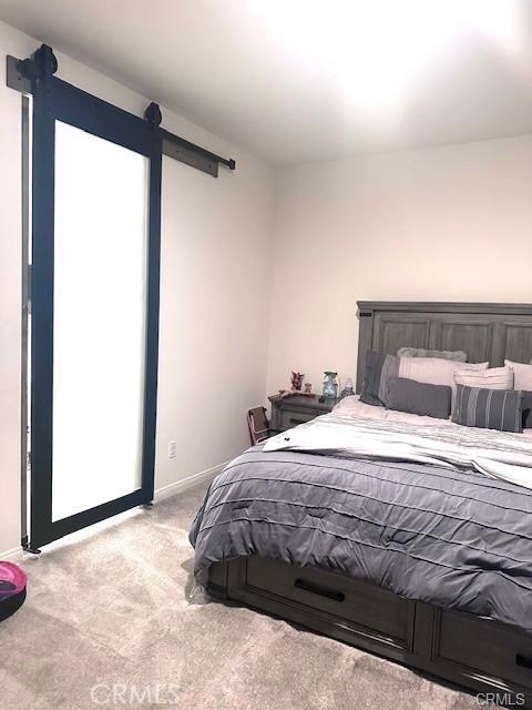 carpeted bedroom with a barn door