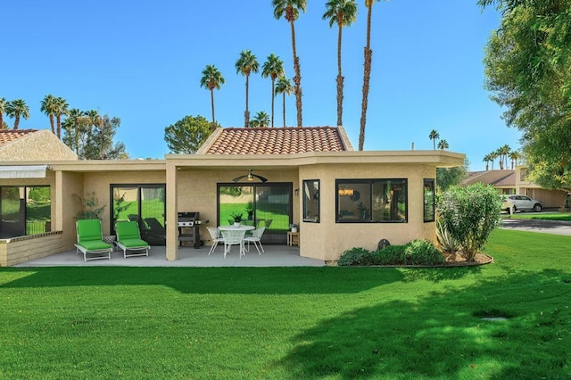 back of house featuring a patio area and a lawn