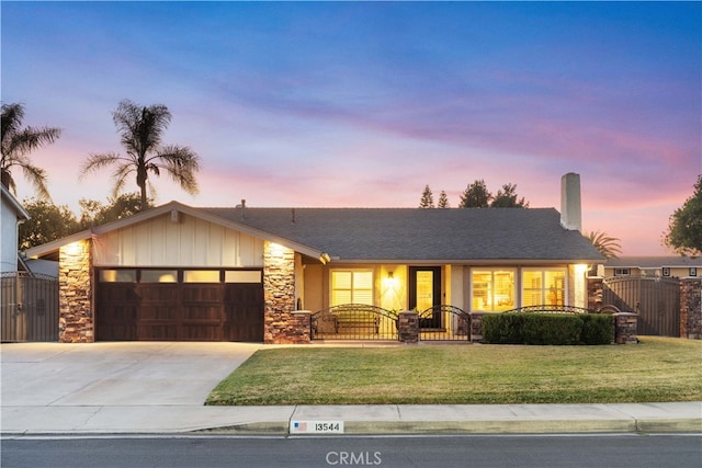 ranch-style house featuring a garage and a lawn