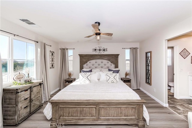 bedroom with light hardwood / wood-style floors, ensuite bath, and ceiling fan