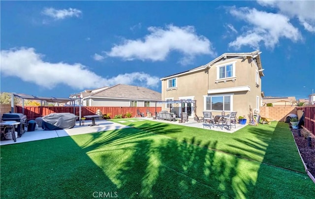 rear view of house with a lawn and a patio area