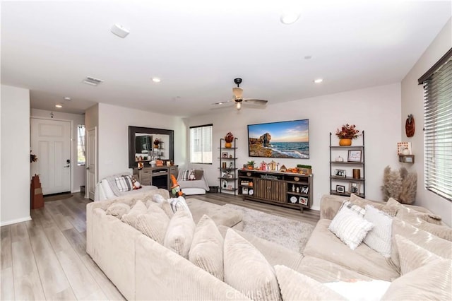 living room featuring ceiling fan and light hardwood / wood-style floors