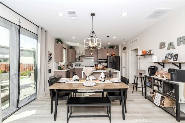 dining room with a chandelier and light wood-type flooring