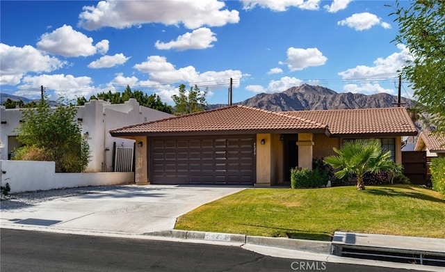 view of front facade featuring a mountain view, a garage, and a front lawn