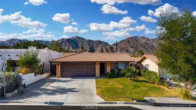 view of front of home with a mountain view, a garage, and a front yard