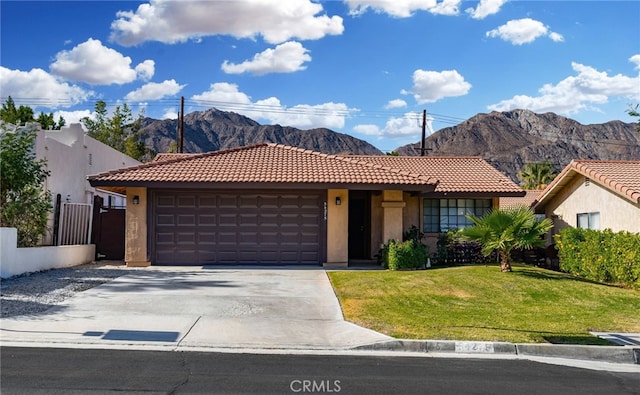 view of front of property featuring a mountain view, a garage, and a front lawn