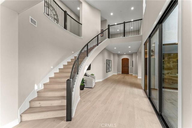 foyer entrance with light hardwood / wood-style flooring and a high ceiling