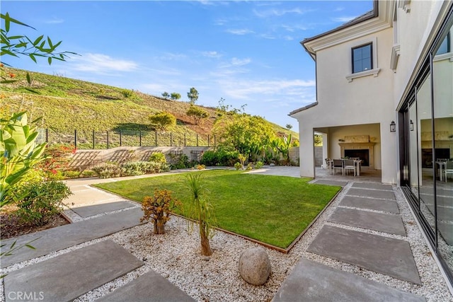 view of yard featuring a patio area and exterior fireplace