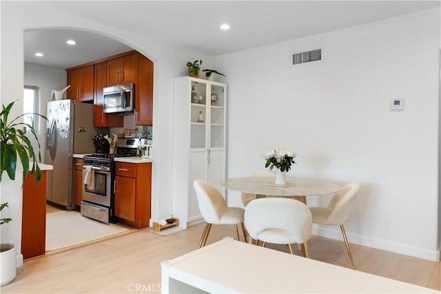 kitchen with light hardwood / wood-style floors and appliances with stainless steel finishes