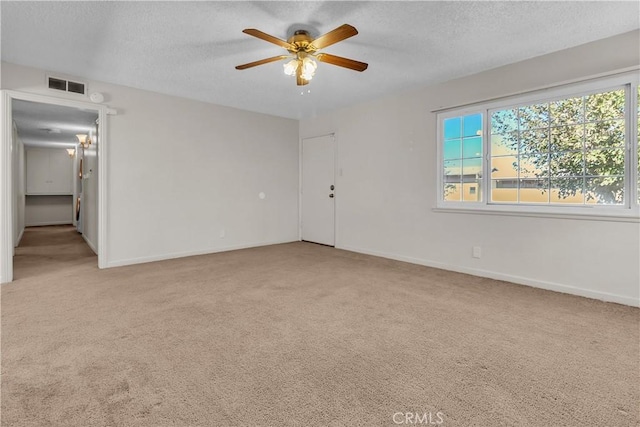 carpeted spare room featuring a textured ceiling and ceiling fan