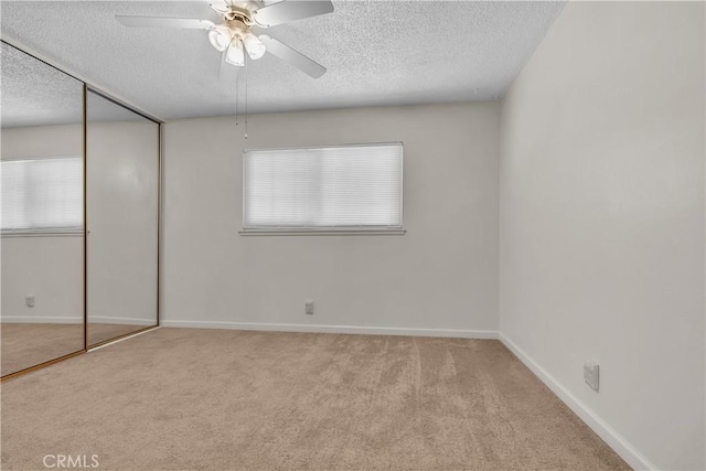 unfurnished bedroom with multiple windows, ceiling fan, a closet, and a textured ceiling