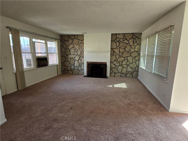 unfurnished living room with a textured ceiling, carpet flooring, and a fireplace with flush hearth