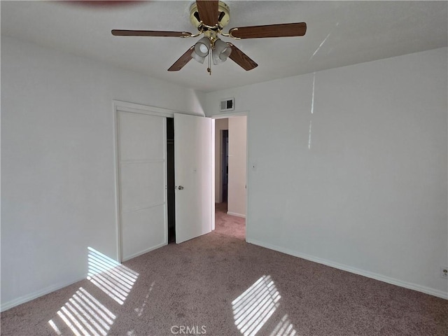 unfurnished bedroom featuring a ceiling fan, visible vents, baseboards, a closet, and carpet