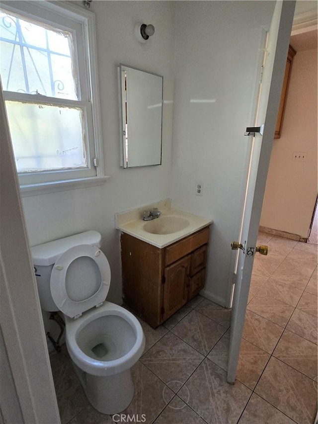 bathroom with toilet, tile patterned flooring, and vanity