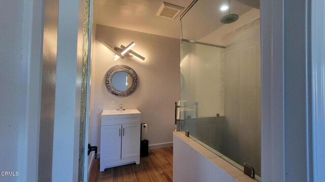 bathroom featuring a shower, vanity, and wood-type flooring