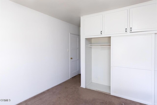 unfurnished bedroom with carpet flooring and a closet