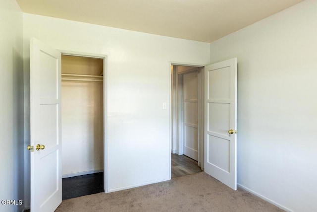 unfurnished bedroom featuring light colored carpet and a closet