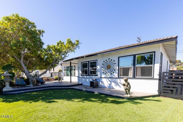 back of house with a lawn and a patio