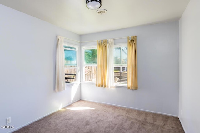 unfurnished room with carpet flooring and baseboards