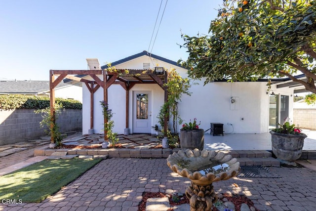 exterior space with a pergola, a patio area, fence, and stucco siding