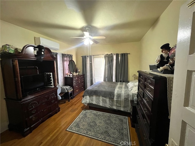 bedroom featuring an AC wall unit, ceiling fan, and hardwood / wood-style floors