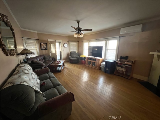 living room with an AC wall unit, crown molding, ceiling fan, and wood-type flooring