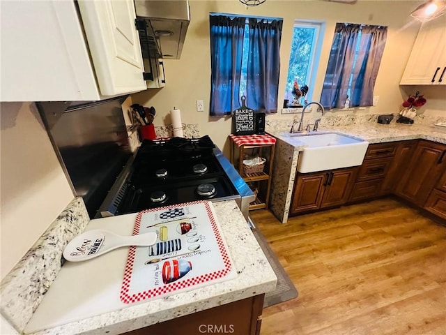 174 E Navilla Pl, Covina, CA 91723 - kitchen with light wood-style flooring, light stone countertops, and white cabinetry