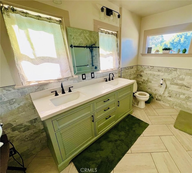 bathroom featuring toilet, vanity, tile walls, and walk in shower