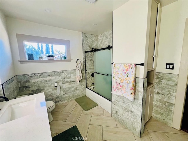 174 E Navilla Pl, Covina, CA 91723 - bathroom featuring tile walls, shower / bath combination with glass door, wainscoting, vanity, and tile patterned floors