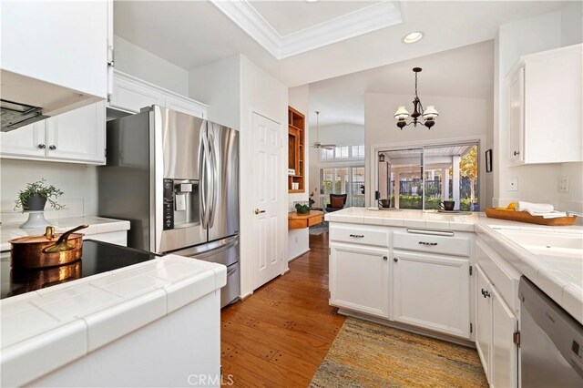 kitchen with tile counters, white cabinetry, and appliances with stainless steel finishes