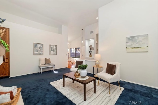 living area with high vaulted ceiling and dark colored carpet