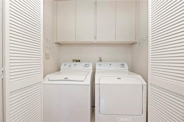 laundry room featuring washer and dryer and cabinets