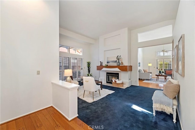 sitting room featuring wood-type flooring and ceiling fan