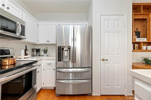 kitchen featuring white cabinets, appliances with stainless steel finishes, and light hardwood / wood-style floors