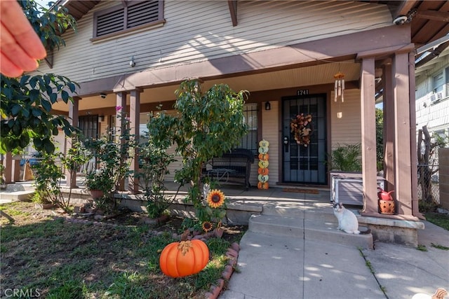 view of exterior entry featuring covered porch