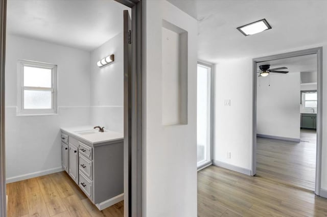 bathroom featuring hardwood / wood-style flooring, vanity, ceiling fan, and a healthy amount of sunlight