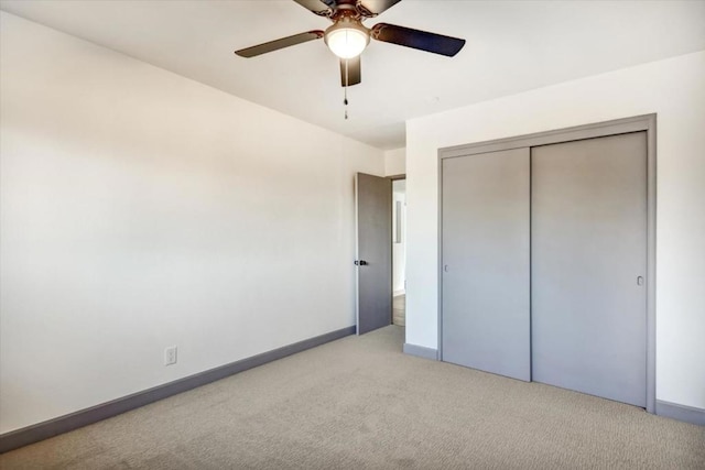 unfurnished bedroom with light carpet, ceiling fan, and a closet