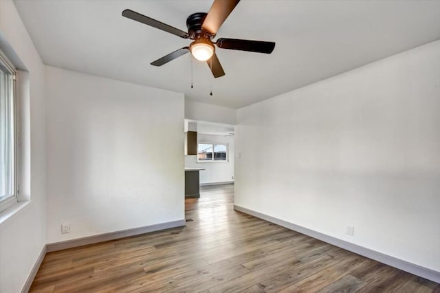 unfurnished room with ceiling fan and hardwood / wood-style flooring